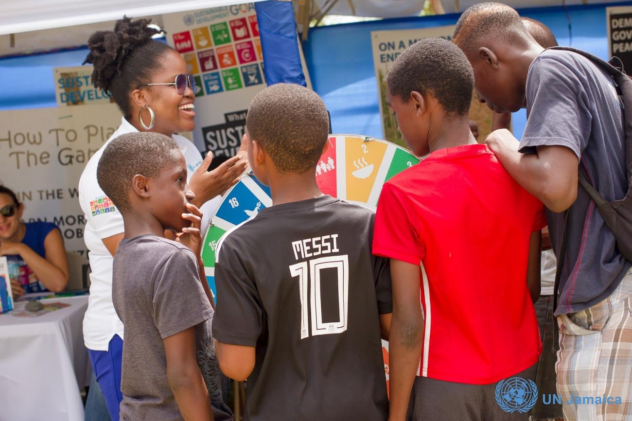 UN Jamaica team member, Jheanelle Hemmings takes these young patrons through the wheel game